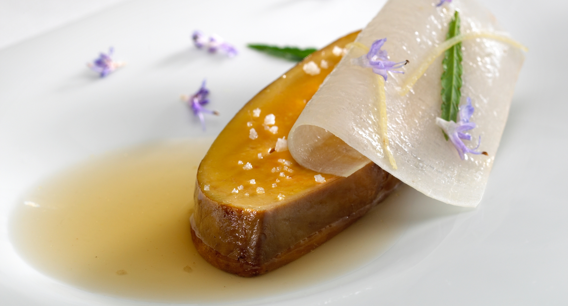 Roast escalope of foie gras served on a charcoal grill. Crystallised yucca in a date-stone consommé. Marigold flowers [Tagetes signata pumila].
PHOTO: José Luis López de Zubiría / Mugaritz