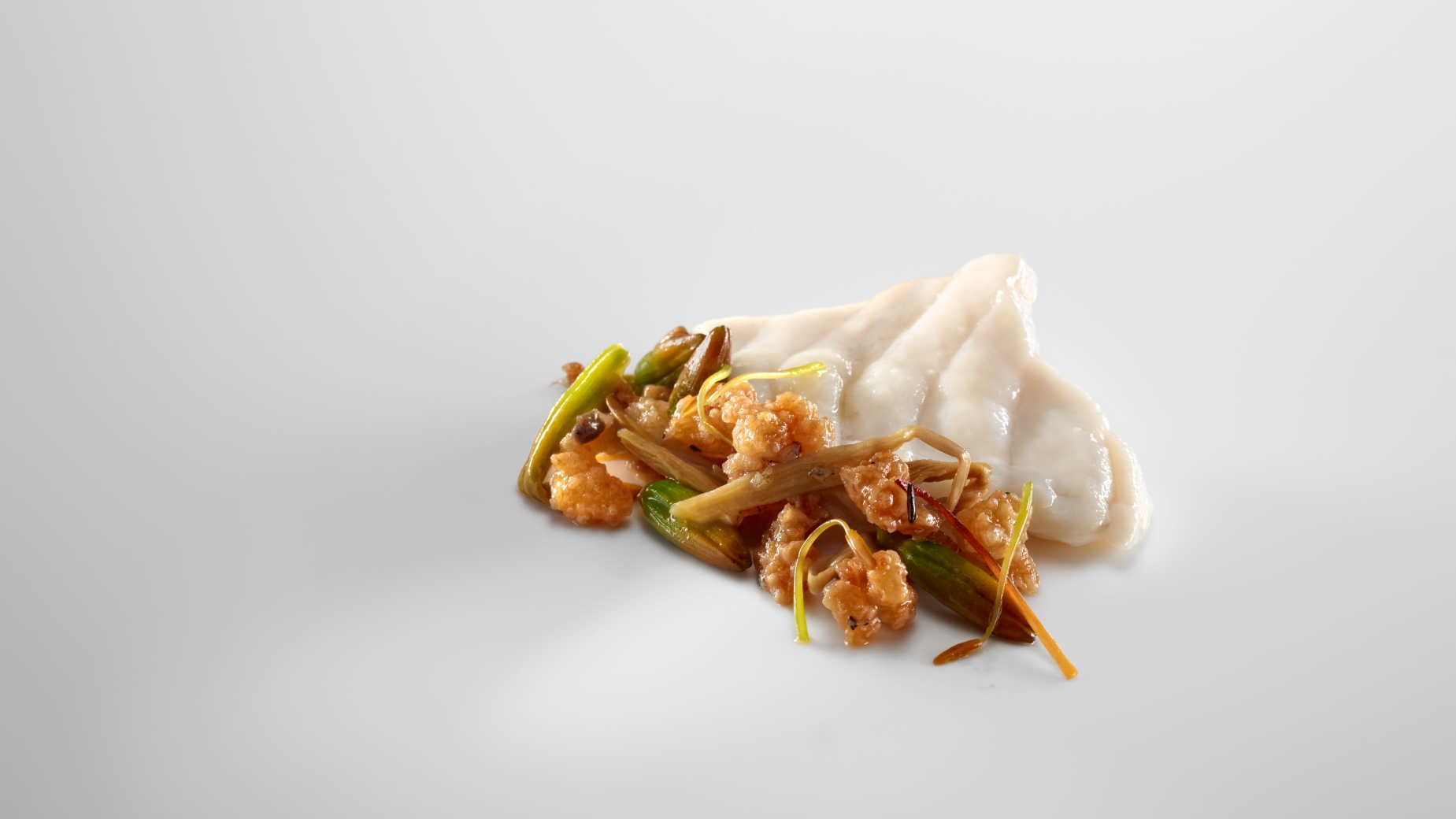 Slices of monkfish cooked with the steam of its bones. Crispy stew of roasted rinds and lilies.
PHOTO: José Luis López de Zubiría / Mugaritz